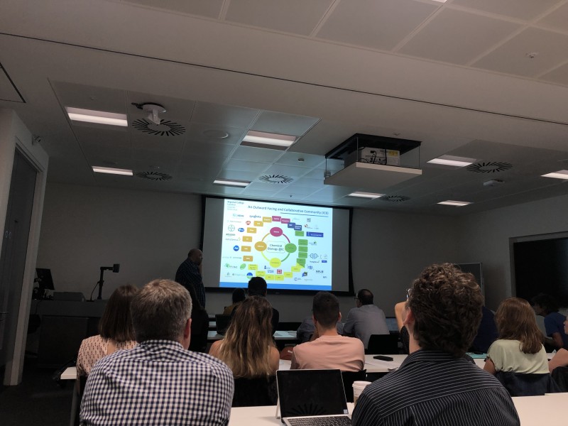 Group watching presentation at Mixing chemistry with medical research event